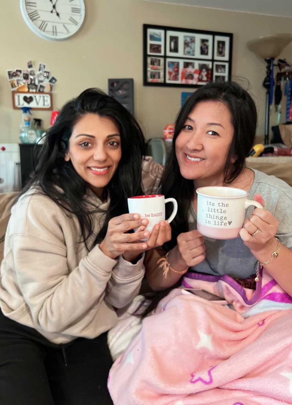 Two friends laughing and having coffzz at table